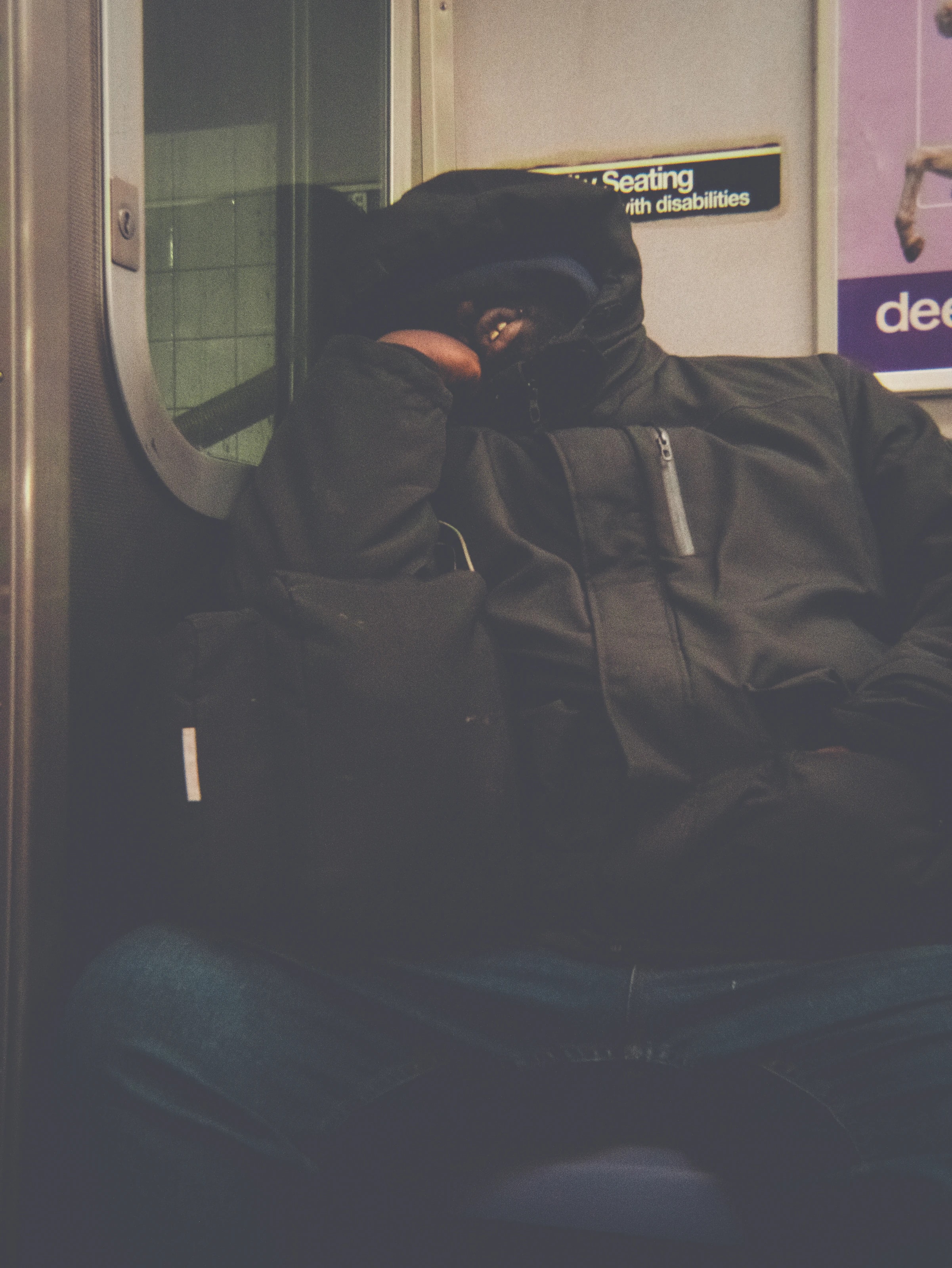 Person asleep on a seat in the subway, New York