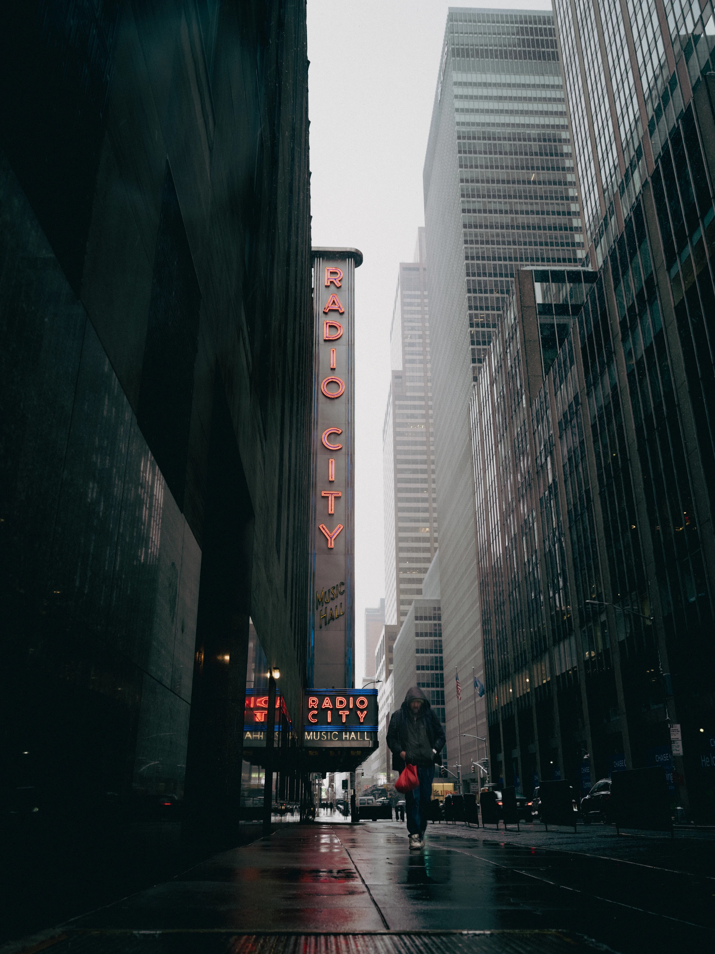 Man with a red bag in front of Radio City Music Hall, New York