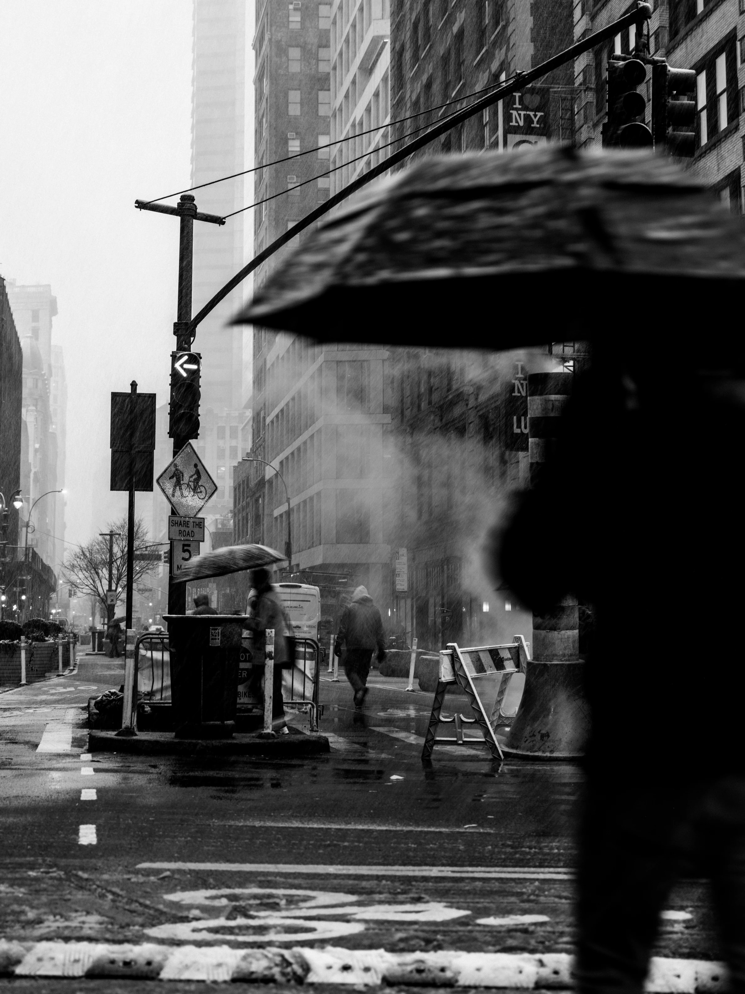 Large umbrella in front of a hazy intersection, New York