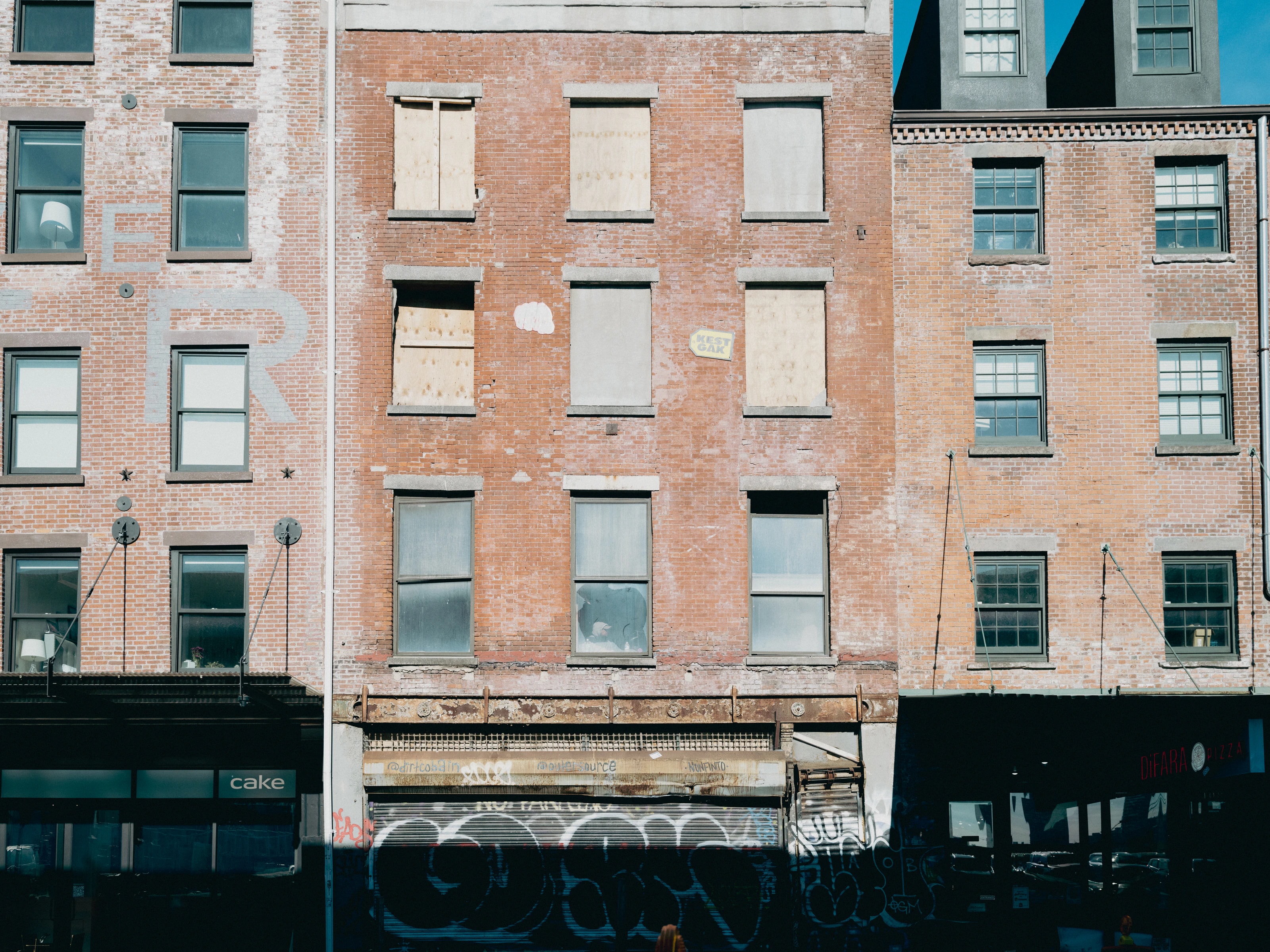 Brick facade with windows, a man sitting in one of them, New York