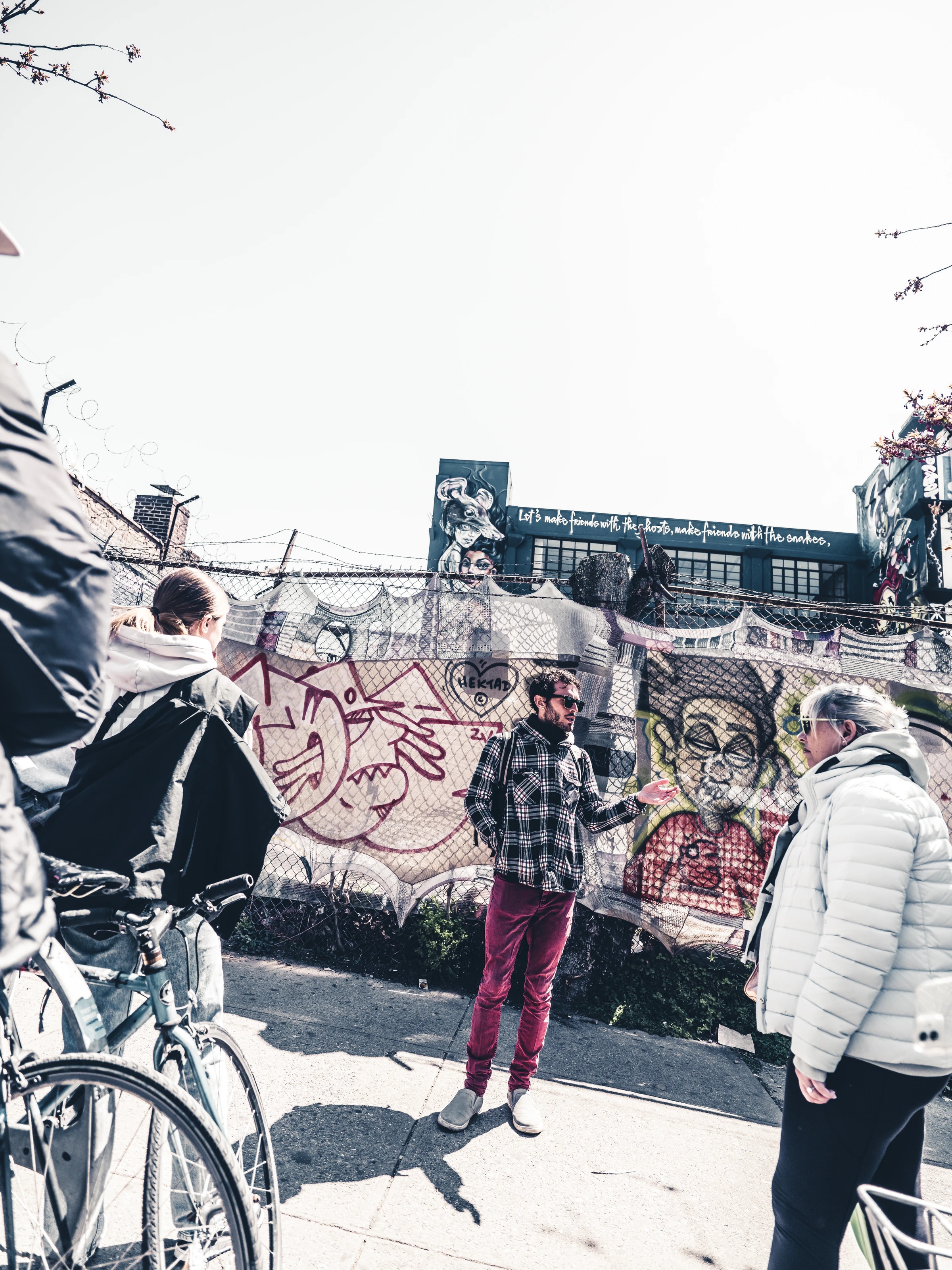 Man in front of a graffiti wall talking to listeners, New York